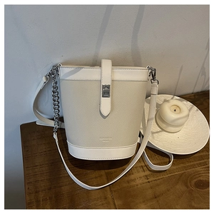Detailed close-up of cream white bucket bag with pebble leather texture and metal buckle