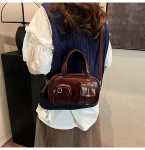 Detail of vintage dark brown faux leather bag with two exterior pockets and thin strap