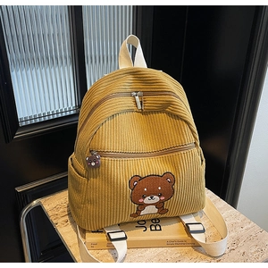 Detail of ginger corduroy backpack featuring bear embroidery and soft rubber zipper pull