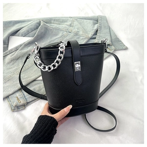 Detail of black lychee grain bucket bag with silver chain handle and metal buckle closure