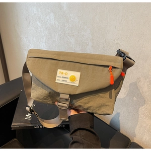 Detail der khakifarbene Nylon-Kuriertasche mit orangefarbenem Reißverschluss und Logo