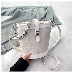 Detail of white bucket bag with pebble leather texture and silver twist lock