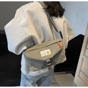 Detailansicht der Rückseite einer olivgrünen Kuriertasche mit orangen Reißverschlüssen