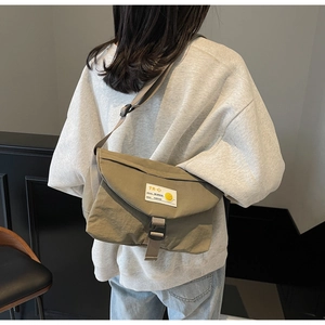 Details der khakifarbenen Kuriertasche mit Kunststoffschnalle und Nylonriemen