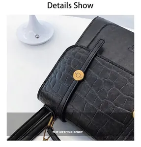 Detail view of black faux leather backpack with crocodile texture and gold metal ring buckle