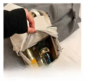 Detail showing the internal storage capacity of the beige leather backpack with items