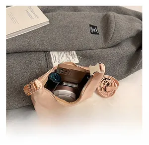 Capacité interne du sac à bandoulière beige montrant le rangement du téléphone et maquillage
