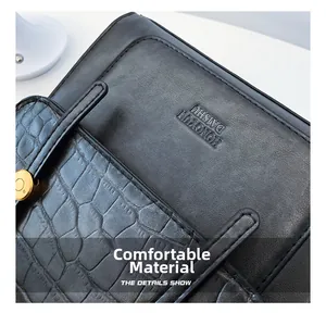 Macro detail of smooth black leather and crocodile pattern texture with embossed logo