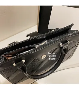 Dettaglio della cerniera argento e trama della pelle su una borsa a mano nera grande