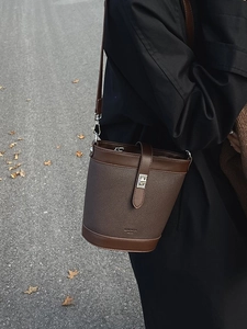 Retro brown bucket bag in pebbled leather with vintage metal lock and adjustable strap