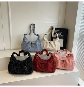 Five colors of corduroy tote bags with sparkling sequins on white tiered pedestals