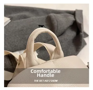 Detail of comfortable handle on cream pebbled leather backpack with neat stitching