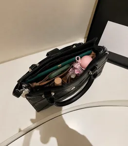 Vue intérieure du sac cabas en cuir noir montrant les compartiments et le rangement