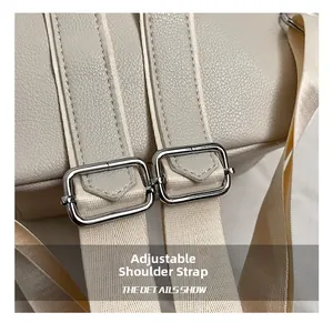 Detail of adjustable woven straps and silver metal buckles on a cream leather backpack