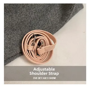 Détail de la bandoulière réglable en cuir rose avec boucle et crochet métalliques