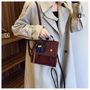 Deep burgundy small square bag with crocodile texture detail and bear pendant