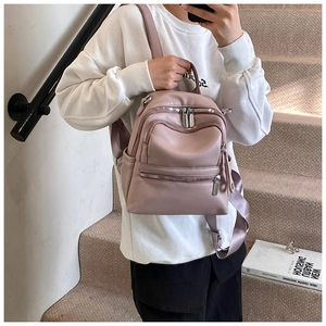 Close-up of litchi textured leather mini backpack in dusty pink with zipper detail