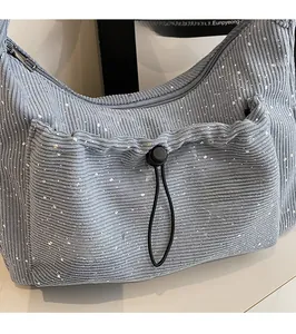 Detail of light blue pleated nylon crossbody bag showing corduroy texture and sequins