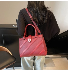 Dettaglio della borsa tote in pelle rossa con trama a litchi e goffratura diagonale