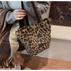 Détail du sac fourre-tout en peluche léopard avec des vêtements décontractés d'hiver