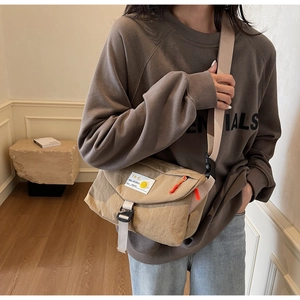 Makroaufnahme der khakifarbenen Nylon-Umhängetasche mit orangefarbenem Zipper