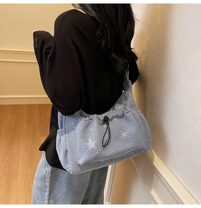 Detail view of light blue corduroy crossbody bag with star pattern on a female model