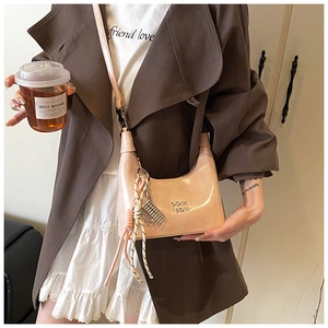 Détail du sac en cuir verni rose avec logo métallique et pendentif à pampilles