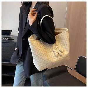 Detail of beige letter jacquard tote bag with stylish puppy leather pendant