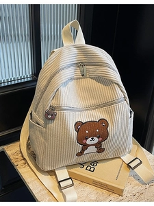 Beige corduroy backpack with cute brown bear embroidery in a lifestyle setting