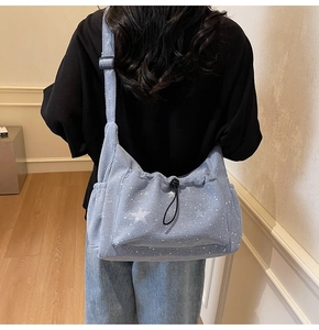 Detail of light blue corduroy tote bag with white stars and drawstring pocket