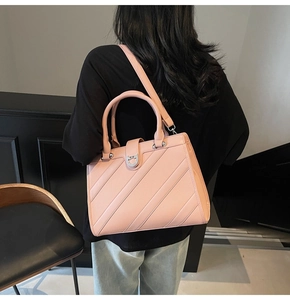 Dettaglio borsa in pelle rosa con strisce diagonali e chiusura in metallo argentato