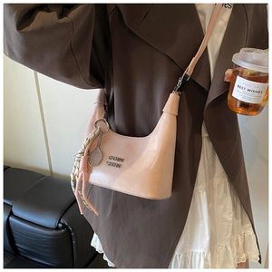 Détail du sac sous l'aisselle en cuir PU rose avec logo en métal et breloque raquette