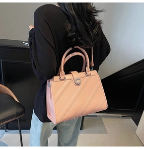 Dettaglio della borsa in pelle rosa con texture diagonale e fibbia metallica