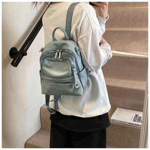Detail of light blue PU leather mini backpack showing zippers and adjustable straps