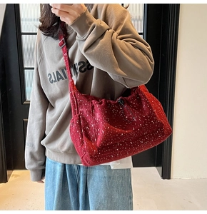 Detail of burgundy corduroy tote bag with white splatter pattern and adjustable strap