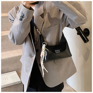 Sac chic en cuir verni noir avec lettrage en métal argenté et breloque raquette de tennis