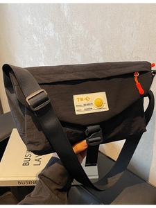 Schwarze Messenger-Bag aus Nylon mit orangefarbenem Reißverschluss und Gurt