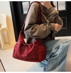 Detail of dark red corduroy tote bag with floral pattern and drawstring closure