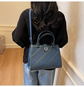 Dettaglio della borsa blu navy con fibbia a ferro di cavallo e tracolla regolabile