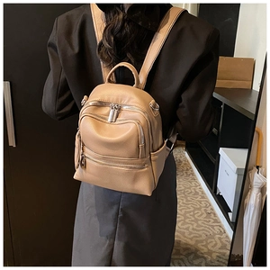 Detail of khaki PU leather mini backpack with litchi texture and silver zippers