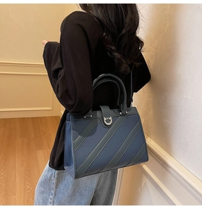 Dettaglio della borsa tote in pelle blu con fibbia a ferro di cavallo e cristalli