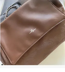 Close-up of MICHTAM brown leather shoulder bag with chain strap and vintage texture