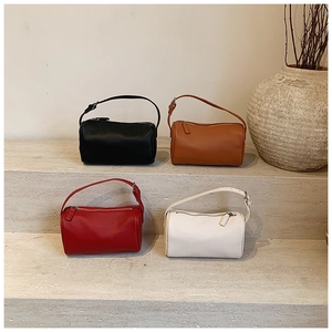 Vue détaillée des sacs polochons en noir, marron, rouge et blanc sur des marches en pierre