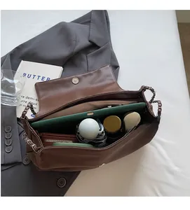 Brown leather tote with silver chain showing interior storage for a tablet and daily essentials