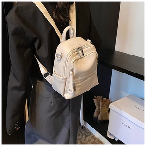 Side view of cream white PU leather backpack with pebble texture on model's back