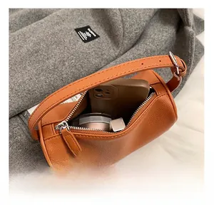 Vue intérieure du sac Boston caramel montrant le rangement du téléphone et maquillage