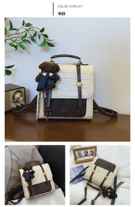 Detail view of off-white crossbody bag with croc texture and bear charm
