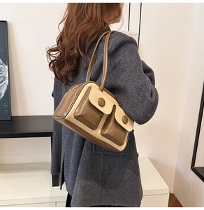 Detail view of contrast stitching shoulder bag in beige and brown patent leather