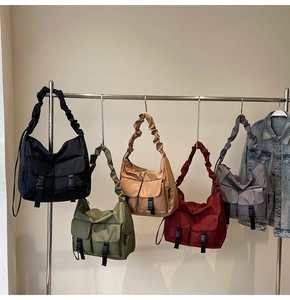 Detail showing five colors of nylon tote bags with cloud straps and cargo pockets
