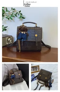 Detail of coffee brown crossbody bag with crocodile texture and cute bear pendant